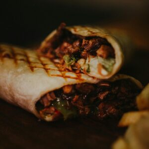 Close-up of a tasty grilled burrito with meat and vegetables, perfect for lunch.