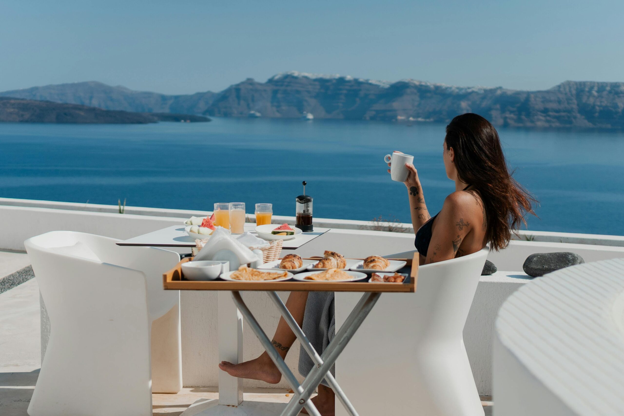 Enjoy a relaxing breakfast by the sea with a stunning view of Santorini's caldera.