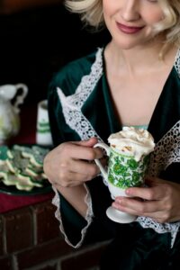 Warm St. Patrick's Day scene featuring a woman enjoying coffee with cookies indoors.