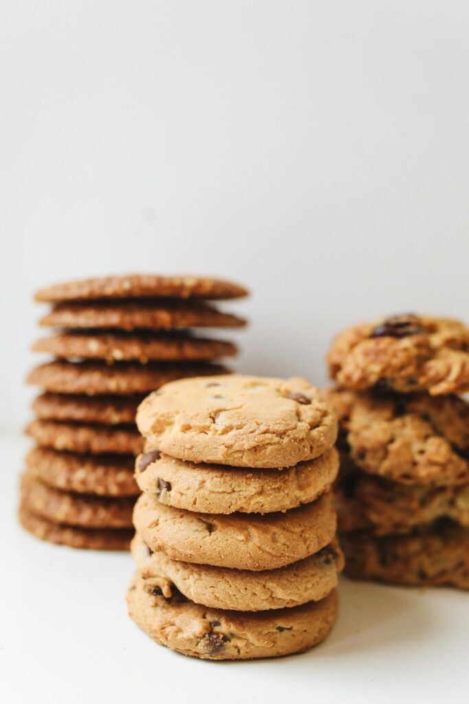 pexels photo 4110541 4110541 A variety of delicious homemade cookies stacked neatly in piles on a white background.