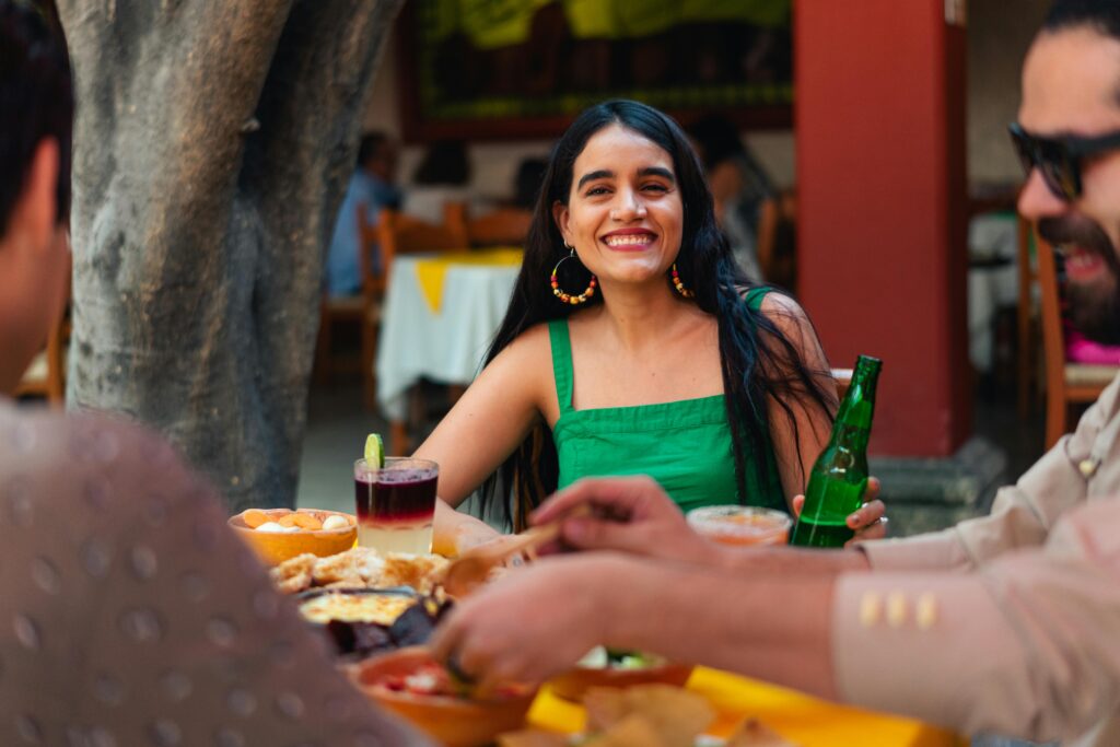 Group of friends enjoying food and drinks at a Mexican restaurant outdoor setting.
